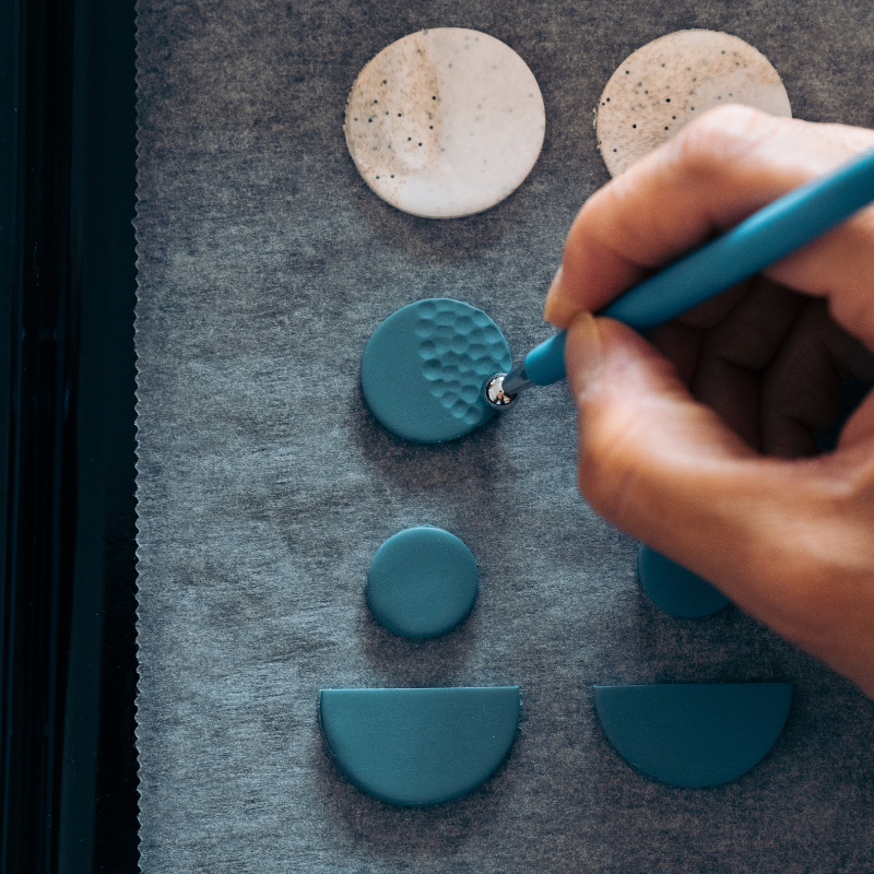 artisan making handmade earrings from clay.