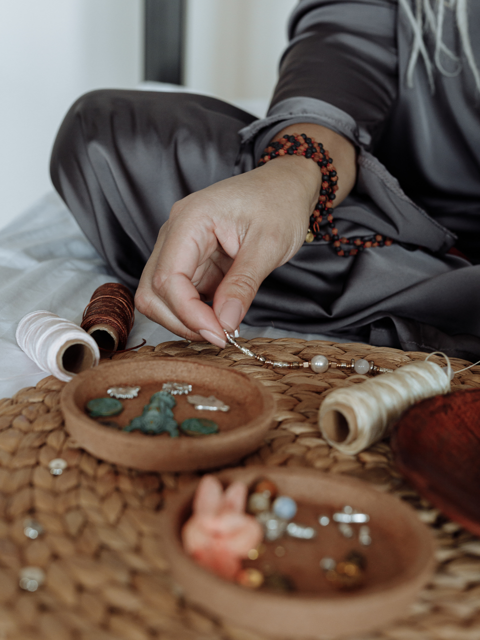 woman is making the beads bracelet.